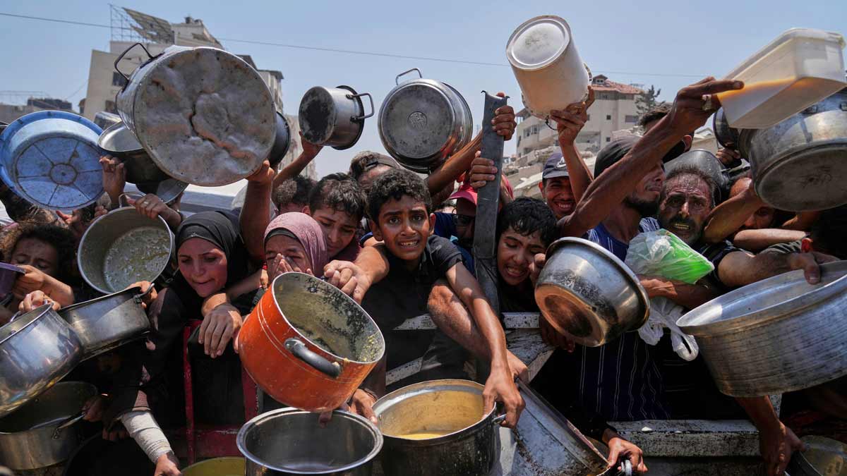 Palestinians struggle to get donated food at a community kitchen in Gaza City | AP