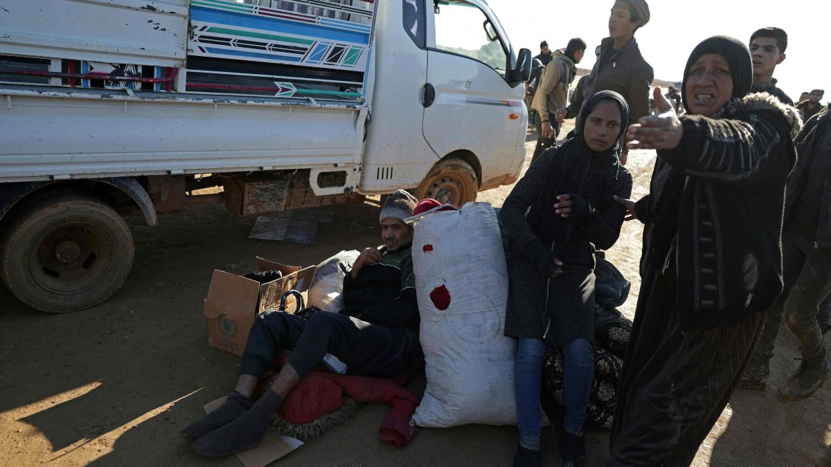 People along with their belongings flee from a Kurdish-controlled area, in Rasm al-Harmal, east of Aleppo city | AFP