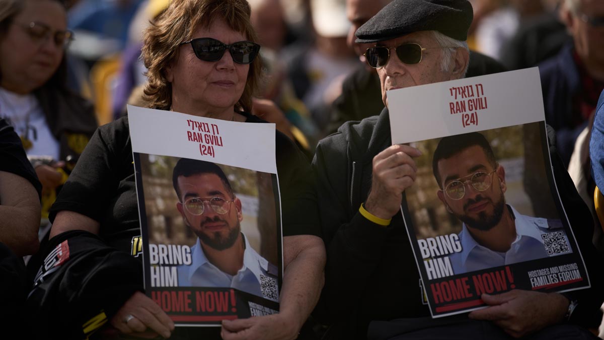 People hold signs with a photo of Ran Gvili, who was killed while fighting Hamas militants during the October 7, 2023, attack and whose body has been held in Gaza ever since, during a rally calling for his return in Tel Aviv, Israel | AP 