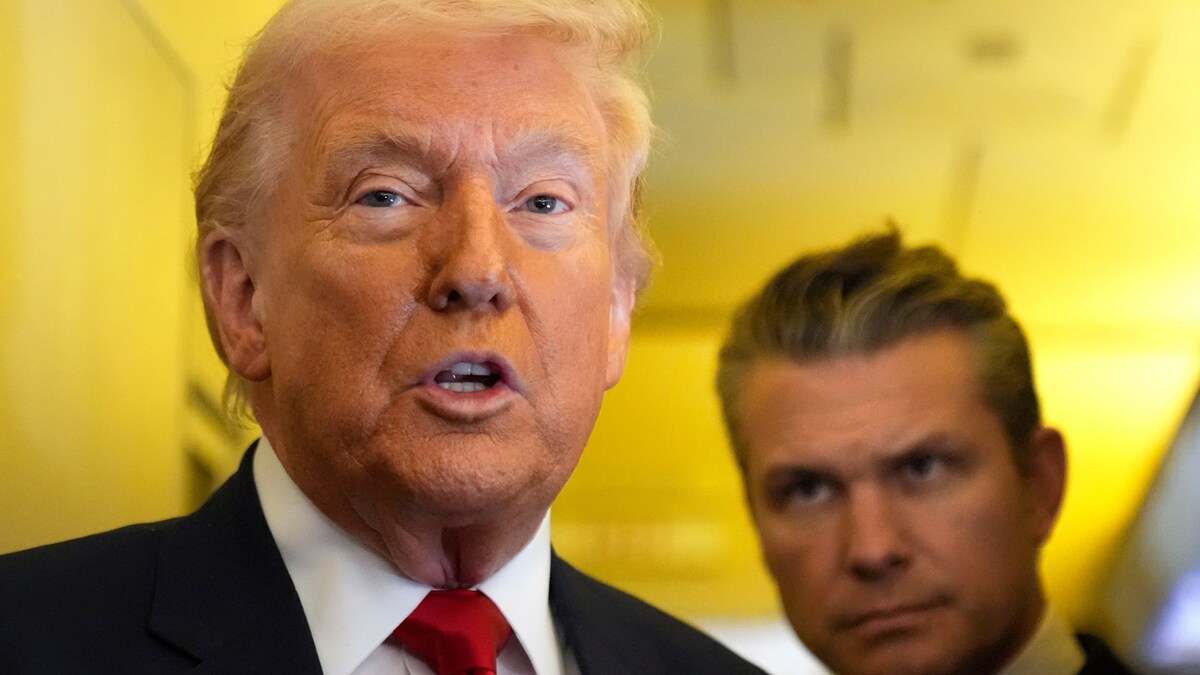 President Donald Trump speaks to reporters as Defense Secretary Pete Hegseth listens while traveling aboard Air Force One | AP
