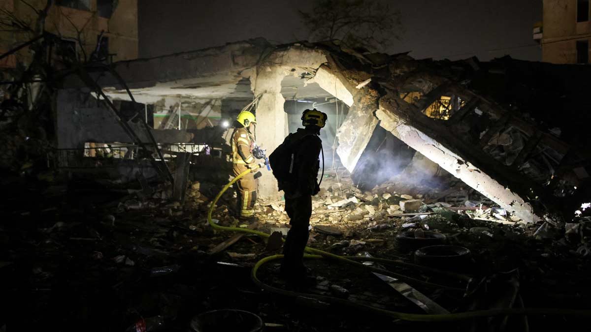 An Israeli firefighter works to put out a fire after Iranian missile barrages struck Dimona | Reuters
