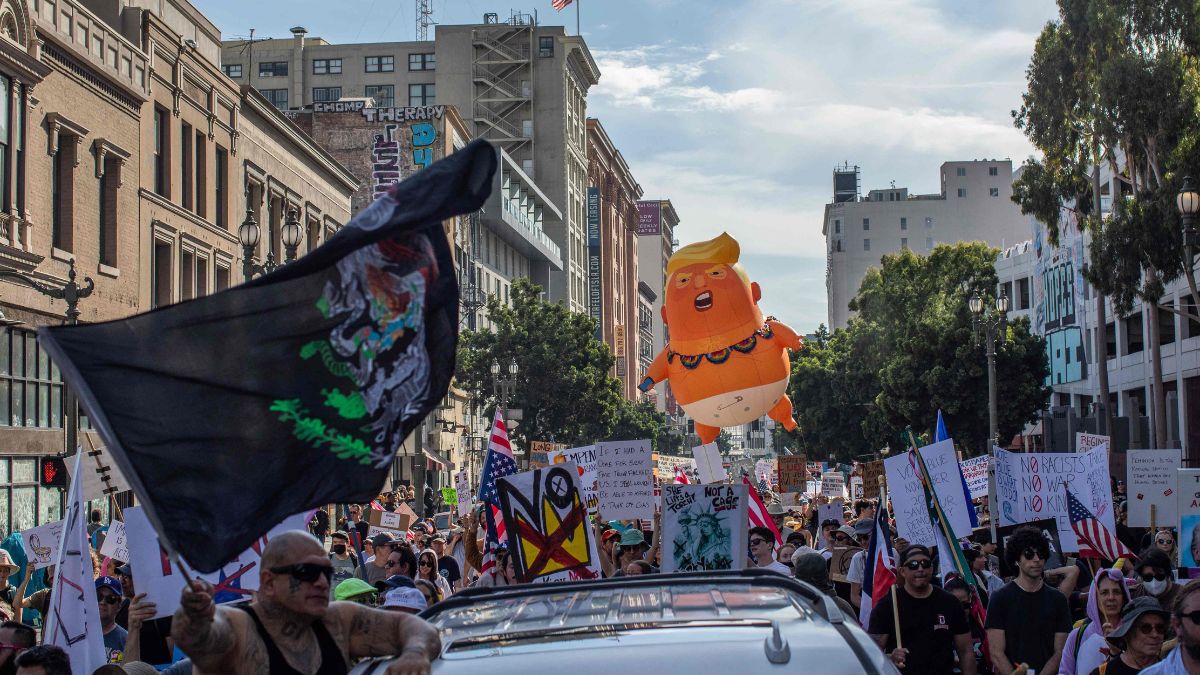 People hold signs during a national 'No Kings' protest on March 28, 2026 in Los Angeles, California | AFP