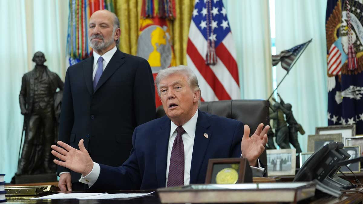President Donald Trump answers questions from reporters after signing an executive order in the Oval Office of the White House on Tuesday | AP