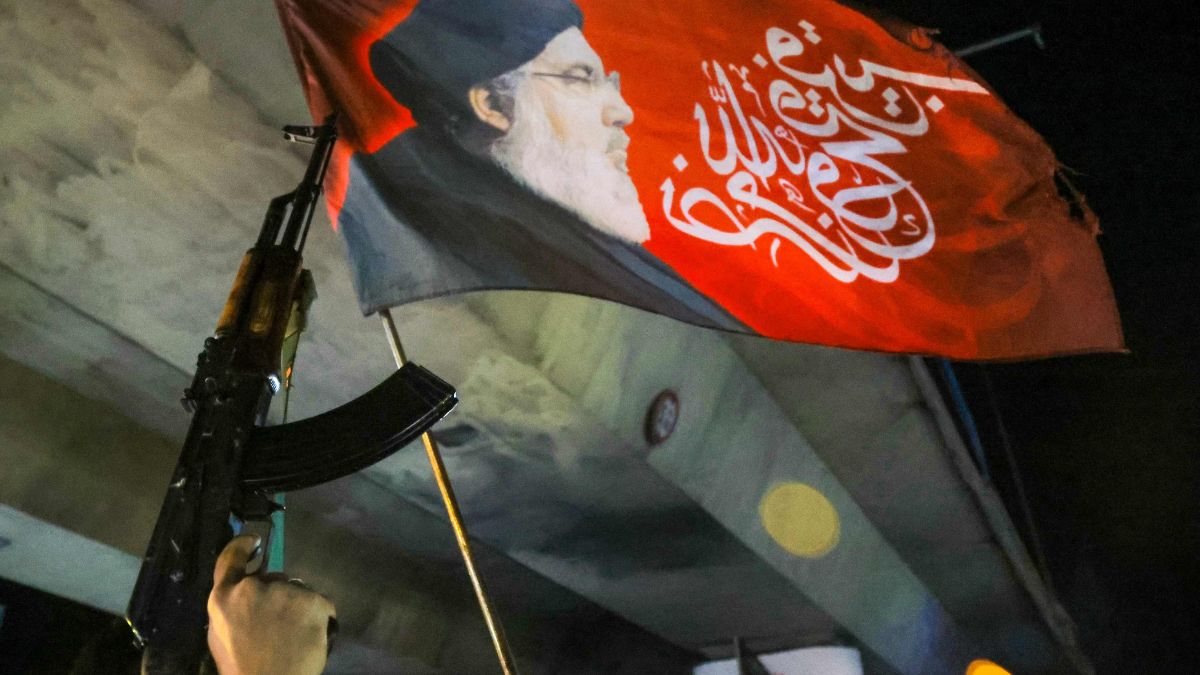 A supporter of Hezbollah holds a machine gun while celebrating the ceasefire with Israel as it takes effect, in the southern suburbs of Beirut, Lebanon | AFP 