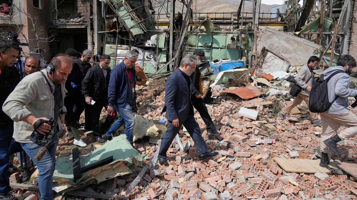 Iran's Minister of Science, Research and Technology Hossein Simaei Sarraf, center, visits the location that was hit during US-Israeli airstrikes Friday at Shahid Beheshti University in Tehran | AP