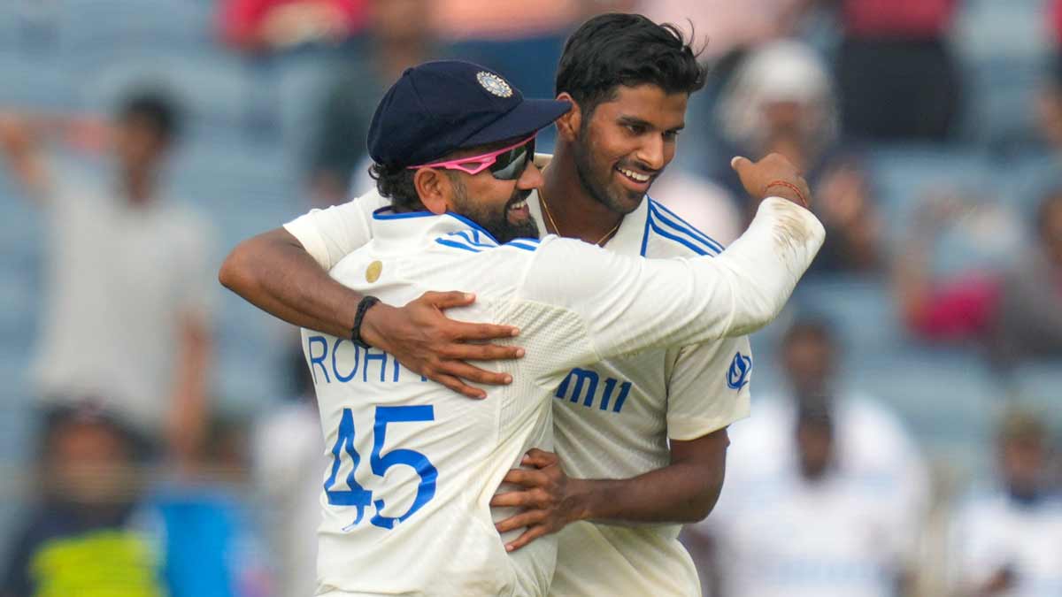 Washington Sundar, right, and captain Rohit Sharma celebrate the dismissal of New Zealand's Tim Southee on day 1 of the second Test match, in Pune | AP
