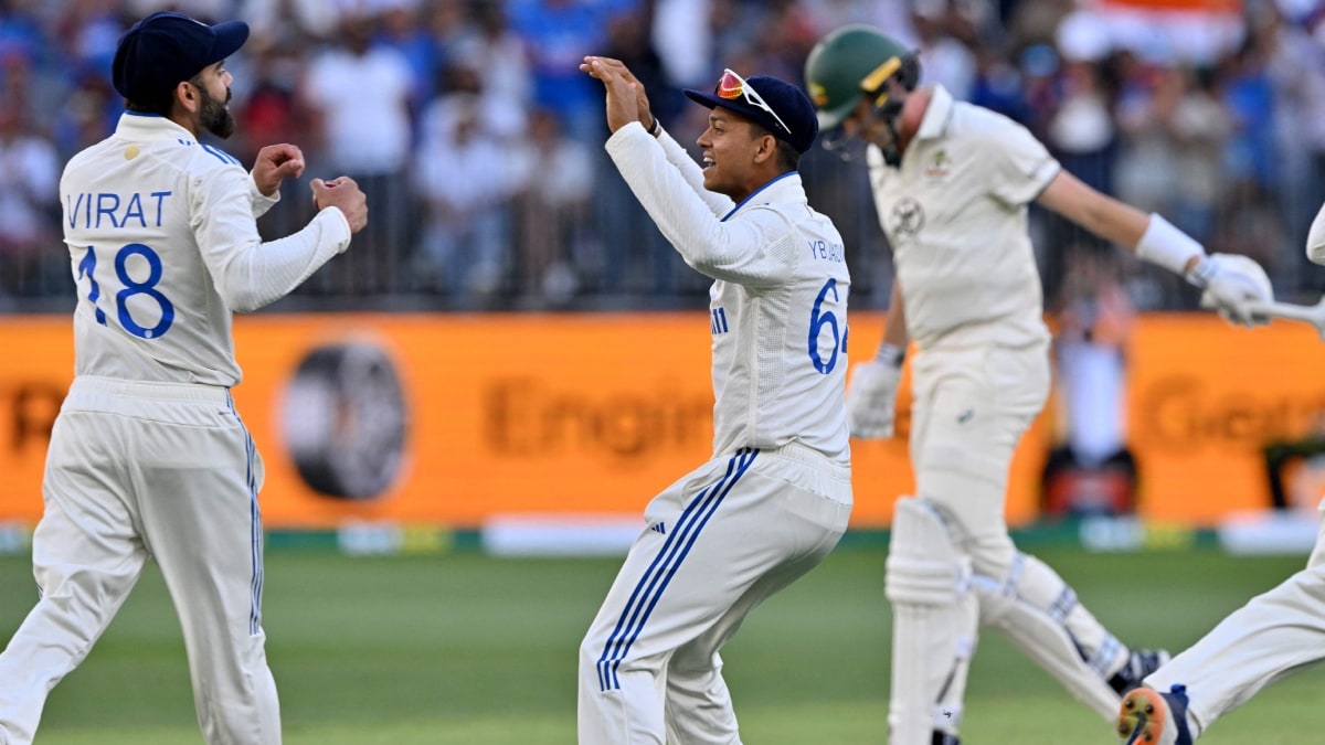 Indias Virat Kohli (L) celebrates his successful catch to dismiss Australias Pat Cummins with teammate Yashasvi Jaiswal during day three of the first Test cricket match between Australia and India at Optus Stadium in Perth | AFP