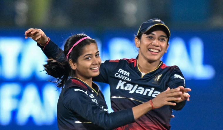 Royal Challengers Bangalore's Shreyanka Patil (L) celebrates with captain Smriti Mandhana (R) after dismissing Delhi Capitals' Meg Lanning during the WPL final, in New Delhi | AFP