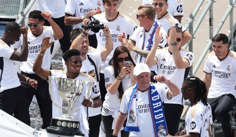 Real Madrid coach Carlo Ancelotti along with Aurelien Tchouameni, Eduardo Camavinga and teammates wave to the fans and display the LaLiga trophy | Reuters