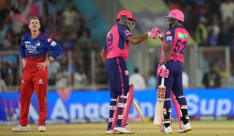 Royal Challengers Bengaluru's Lockie Ferguson (L) reacts as Rajasthan Royals' Ravichandran Ashwin (C) and Rovman Powell celebrate their victory. | PTI