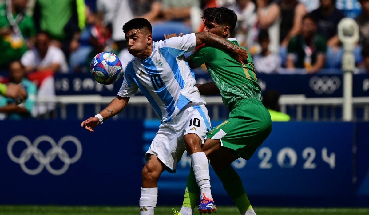 Argentina midfielder Thiago Almada fights for the ball with Iraq's defenderMustafa Saadoon | AFP