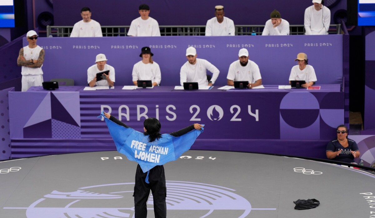 Refugee Team's Manizha Talash, known as Talash, wears a cape which reads "free Afghan women" as she competes during the B-Girls Pre-Qualifier Battle at the breaking competition | AP