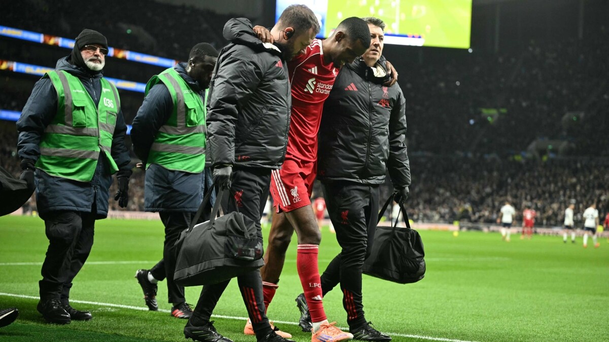 Liverpool striker Alexander Isak is helped off the field by medical staff | AFP
