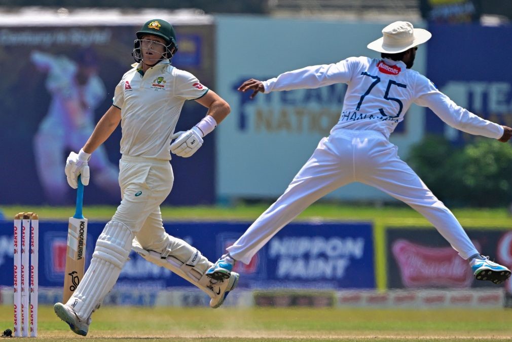 Australia's Marnus Labuschagne (L) runs between the wickets as Sri Lanka's Dhananjaya de Silva jumps to field the ball | AFP