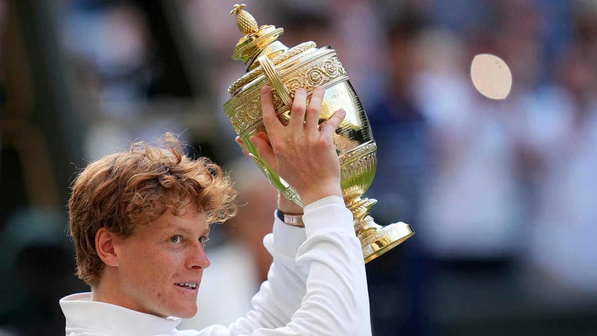 Italy's Jannik Sinner celebrates with the trophy after beating Carlos Alcaraz of Spain to win the men's singles final at the Wimbledon Tennis Championships in London, Sunday, July 13, 2025. (AP Photo/Kin Cheung)