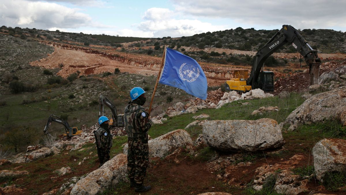 UN peacekeepers hold their flag, as they observe Israeli excavators attempt to destroy tunnels built by Hezbollah, near the southern Lebanese-Israeli border village of Mays al-Jabal, Lebanon, Dec. 13, 2019 | AP