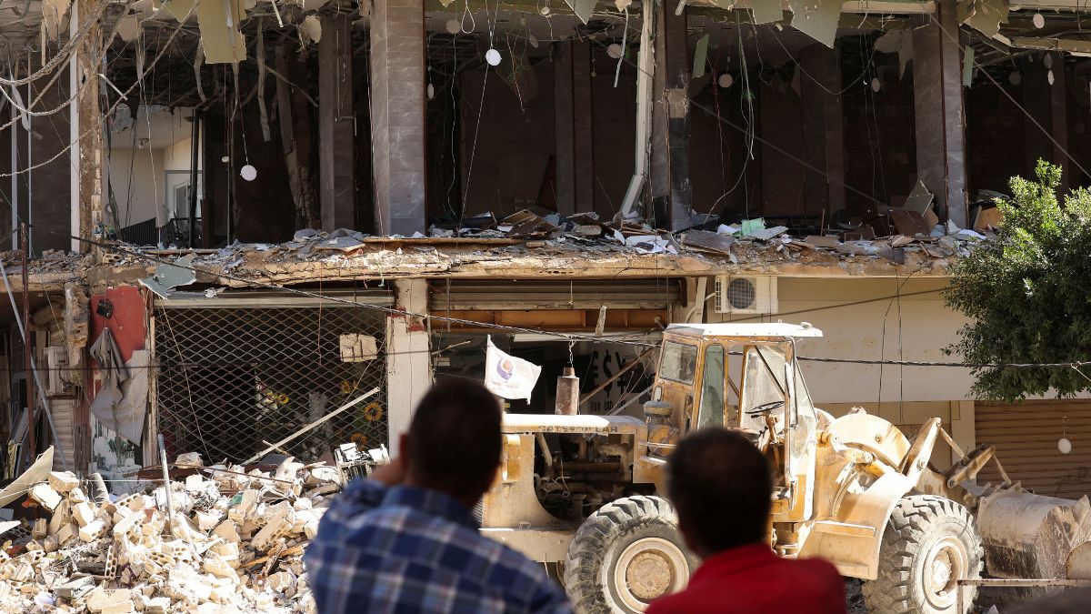 People stand near a damaged branch of ‘Al-Qard al-Hassan', a financial institution linked to Lebanon's Hezbollah in Tyre, Lebanon, on October 21, 2024 | Reuters