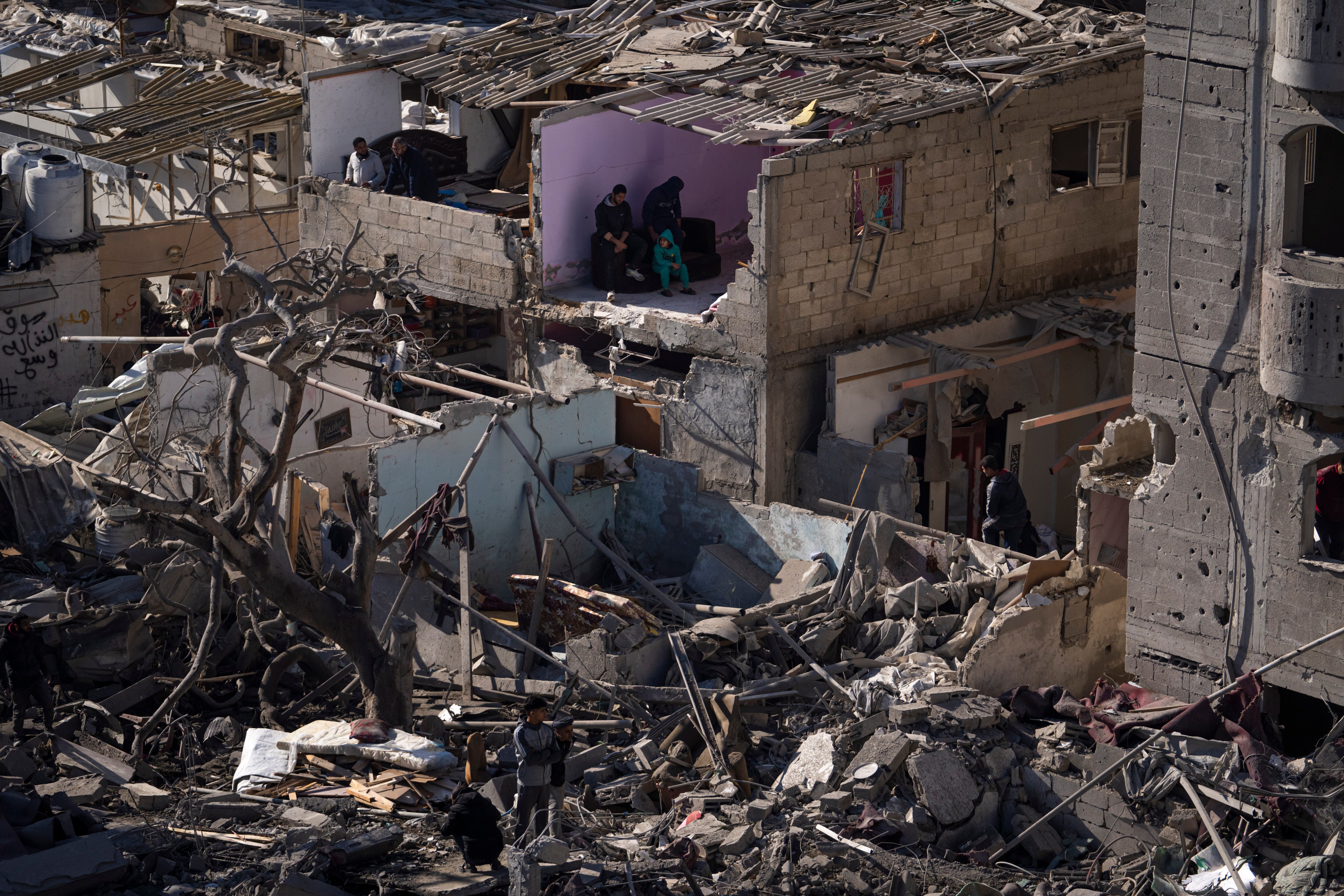 FILE - Palestinians look at the destruction after an Israeli strike on residential buildings and a mosque in Rafah, Gaza Strip, Thursday, Feb. 22, 2024. (AP Photo/Fatima Shbair, File)