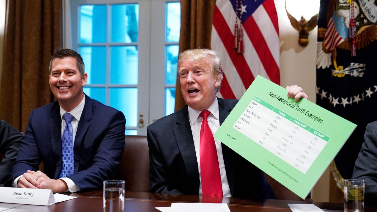 US President Donald Trump, with US Congressman Sean Duffy (L), holds a tariff table as he speaks in the Cabinet Room of the White House on January 24, 2019 | AFP