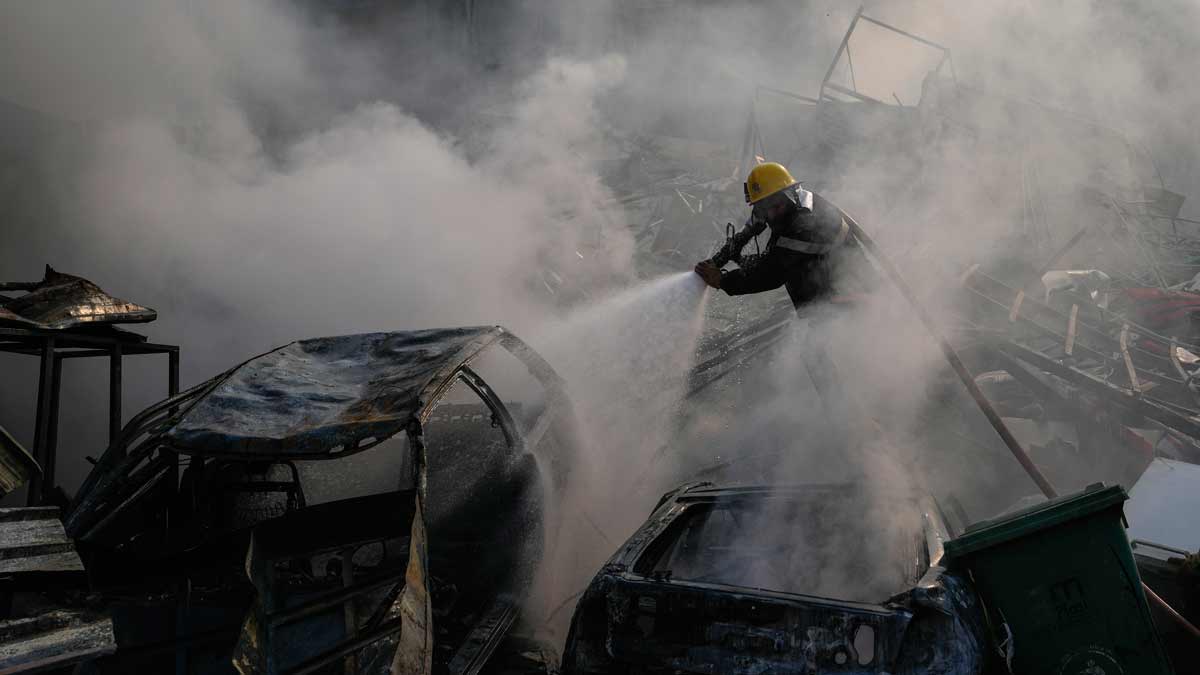 A civil defence worker extinguishes a fire as smoke rises from the site of an Israeli airstrike in Dahiyeh, Beirut, Lebanon | AP