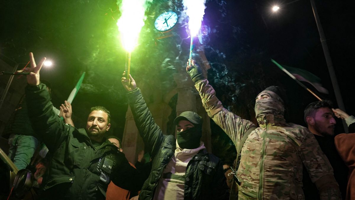 Residents of Syria's northern city of Idlib light flares as they celebrate the control of several districts of Aleppo by Jihadists and their Turkish-backed allies on November 29, 2024 | AP