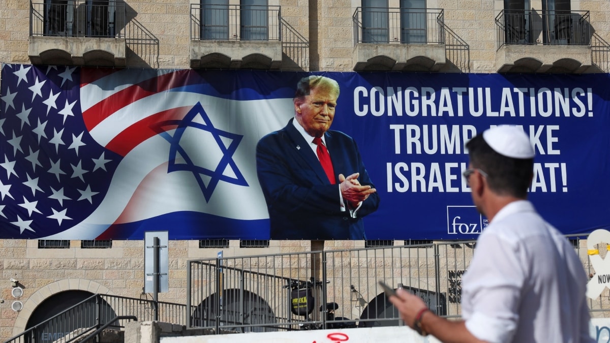 A person walks near a congratulatory billboard for U.S. President-elect Donald Trump in Jerusalem | Reueters