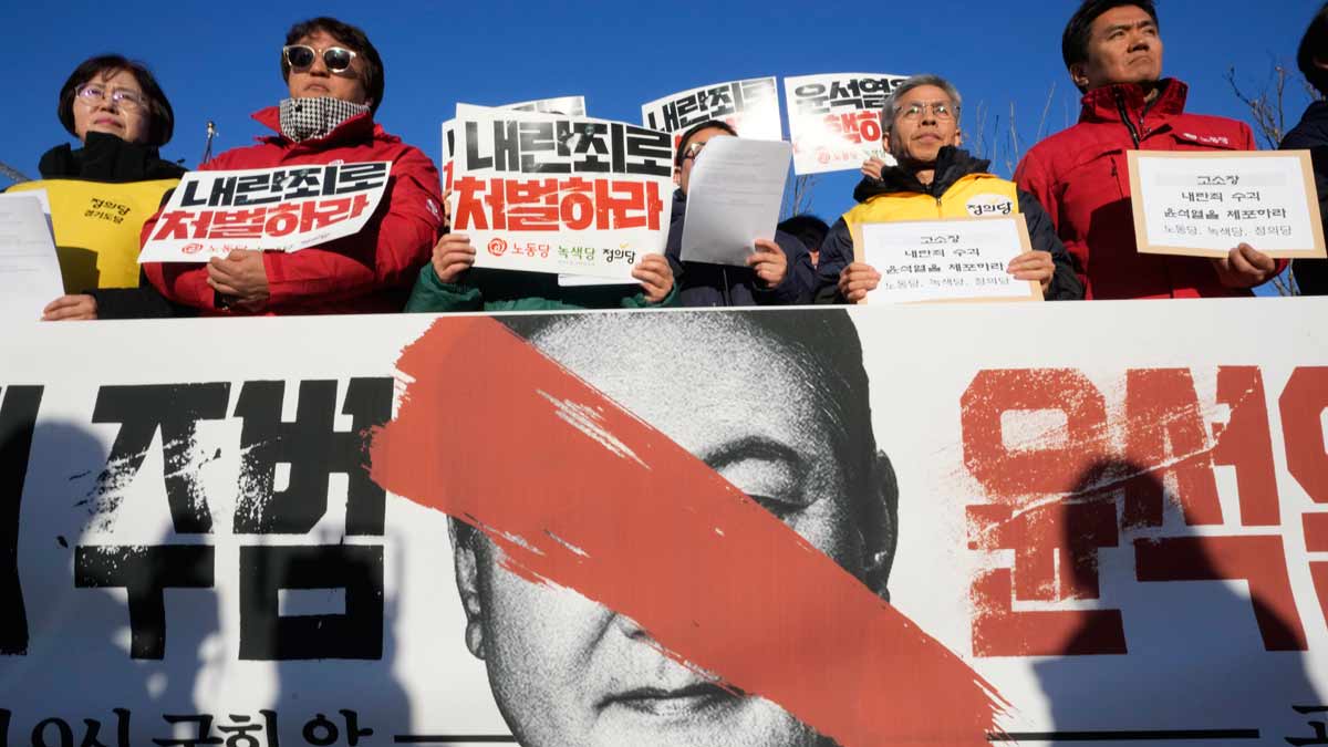 Protesters stage a rally to demand South Korean President Yoon Suk Yeol's resignation, in front of the National Assembly in Seoul. The signs read "Punish” | AP