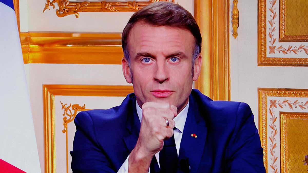 French President Emmanuel Macron is seen on monitors as he addresses the nation during a televised broadcast from the presidential Elysee Palace | AFP