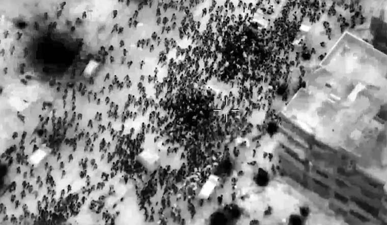 This image grab from a handout video released by the Israeli army shows what the army says are Gazans around aid trucks in Gaza City | AFP