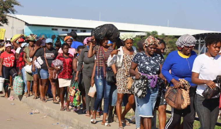 Haitians cross the border between Quanamienthe in Haiti and Dajabon in the Dominican Republic to work in the binational market in Dajabon, Dominican Republic on March 8, 2024 | AFP