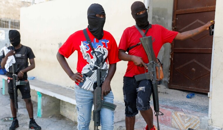 Masked members of "G9 and Family" gang stand guard during a press conference by their leader | AP