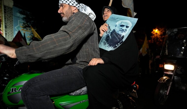 An Iranian demonstrator holds a poster of the late Revolutionary Guard Gen. Mohammad Hadi Haj Rahimi, who was killed in an airstrike widely attributed to Israel that destroyed Iran's Consulate in Syria on April 1, during an anti-Israeli gathering in Tehran | AP