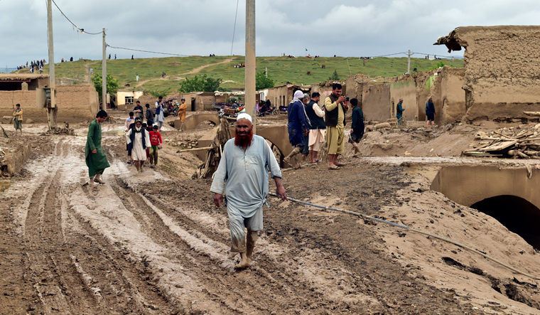 People gather around their damaged houses after heavy flooding in Baghlan province in northern Afghanistan | AP