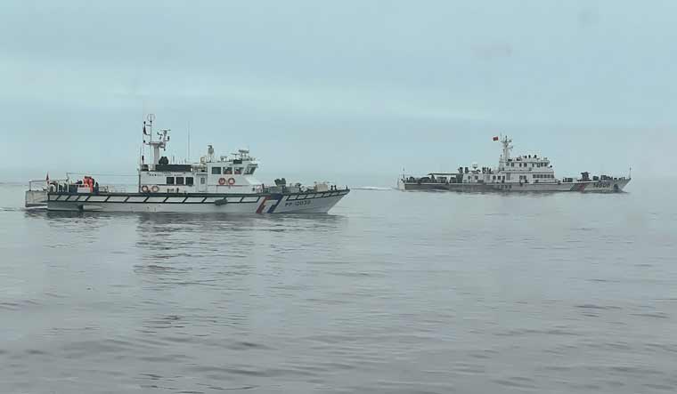 This handout photo taken and released by the Taiwan Coast Guard shows a Taiwan Coast Guard ship (L) monitoring a Chinese Coast Guard ship near Wuqiu Island | AFP