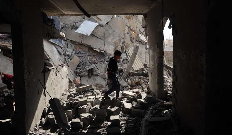A Palestinian boy walks through the rubble following Israeli bombardment of Rafah's Tal al-Sultan district in the southern Gaza Strip | AFP
