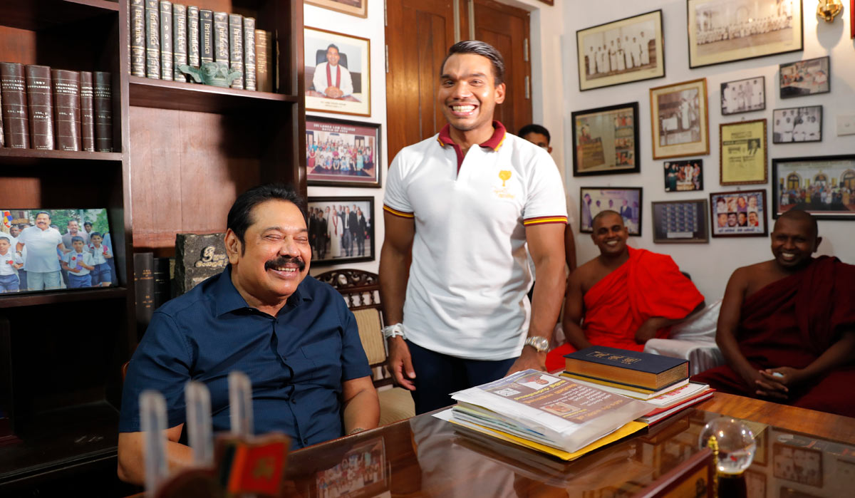 Sri Lankan Prime Minister Mahinda Rajapaksa sits for photographs, with his lawmaker son Namal by his side | AP