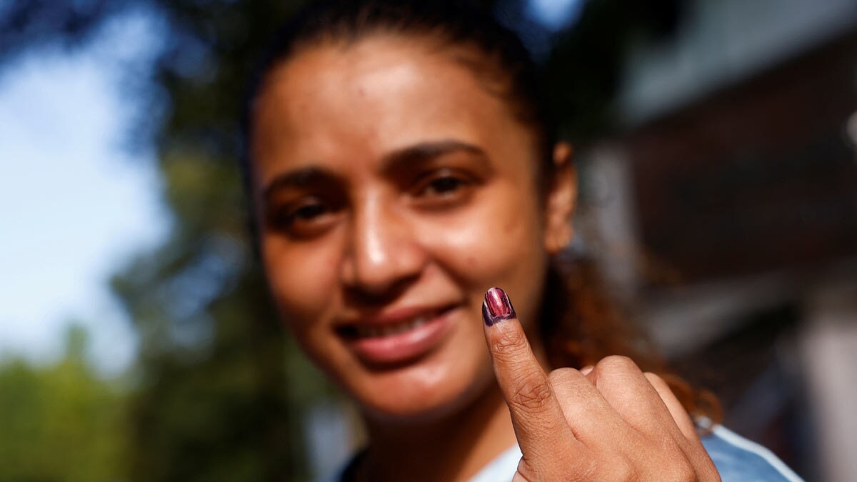 A woman shows her ink-marked finger after voting at a polling station during the presidential election in Colombo, Sri Lanka | Reuters