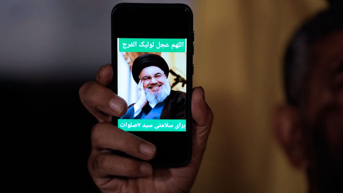 An Iranian demonstrator shows a portrait of Hezbollah leader Hassan Nasrallah on his cell phone in support of Hezbollah at the Felestin (Palestine) Square in downtown Tehran, Iran | AP