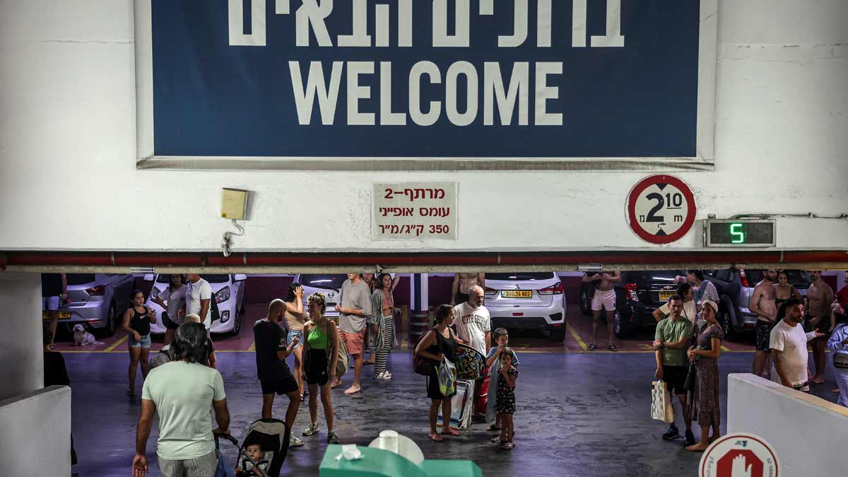 People take shelter during an air raid siren after which Israel's military said a missile was fired from Yemen and intercepted, in Tel Aviv | Reuters