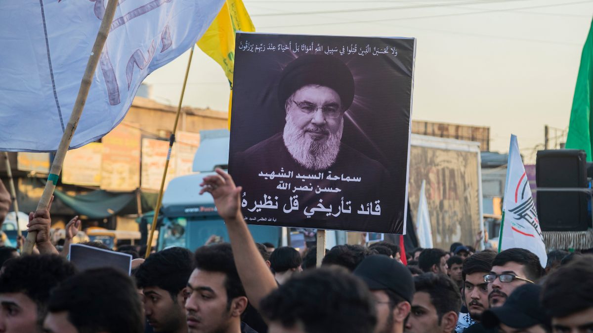 Iraqi Shiites hold pictures of Lebanon's Hezbollah leader Sayyed Hassan Nasrallah