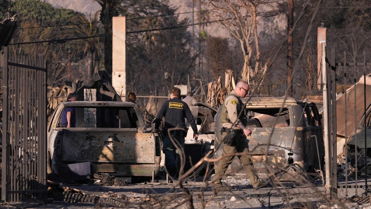 A medical examiner and sheriff's deputies check on a home destroyed by the Eaton Fire at Altadena | AP