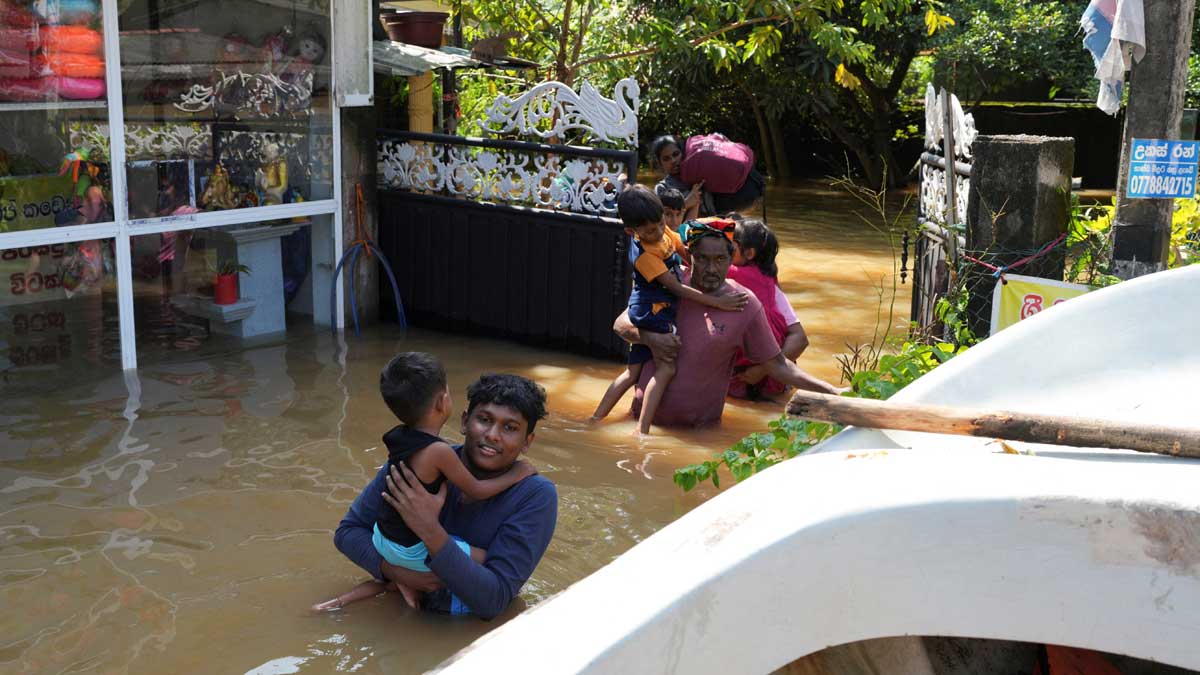 People wade through a flooded area as they head towards a boat, following Cyclone Ditwah in Kelaniya, Sri Lanka | PTI
