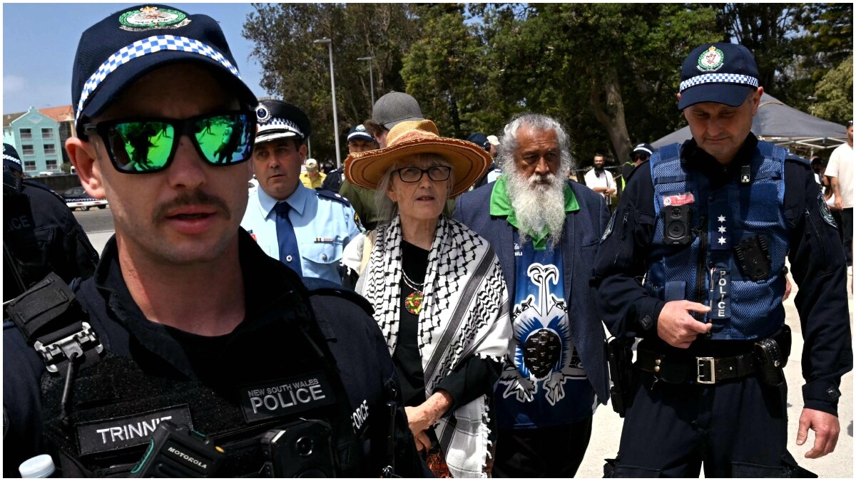 A pro-Palestinian supporter is escorted by police from the Bondi Beach area in Sydney  | AFP