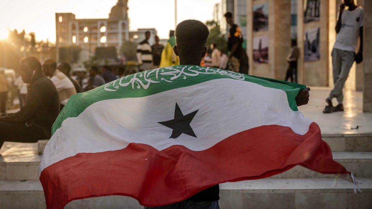 A man holds a flag of Somaliland in front of the Hargeisa War Memorial monument in Hargeisa | AFP