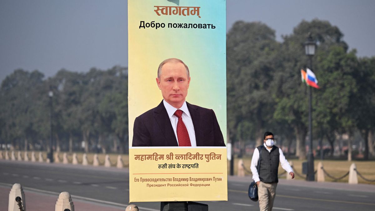 A commuter walks past a poster of Russia's President Vladimir Putin at the Kartavya Path in New Delhi | AFP 