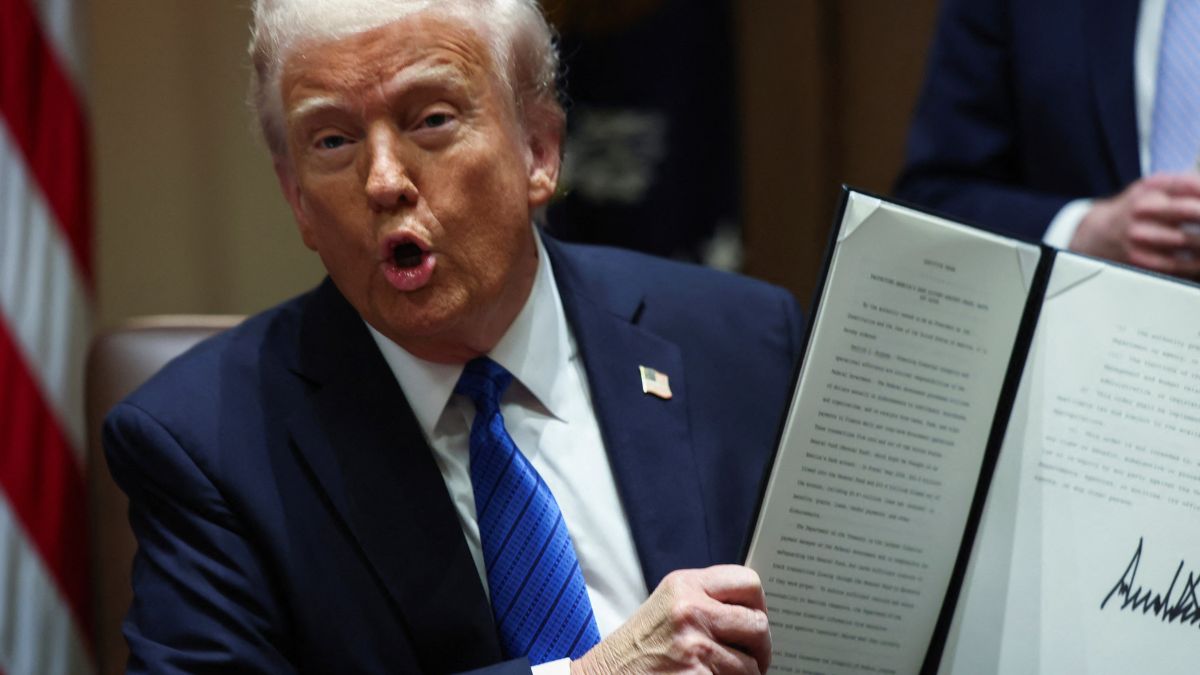 US President Donald Trump holds an executive order, at the White House, in Washington, DC | Reuters