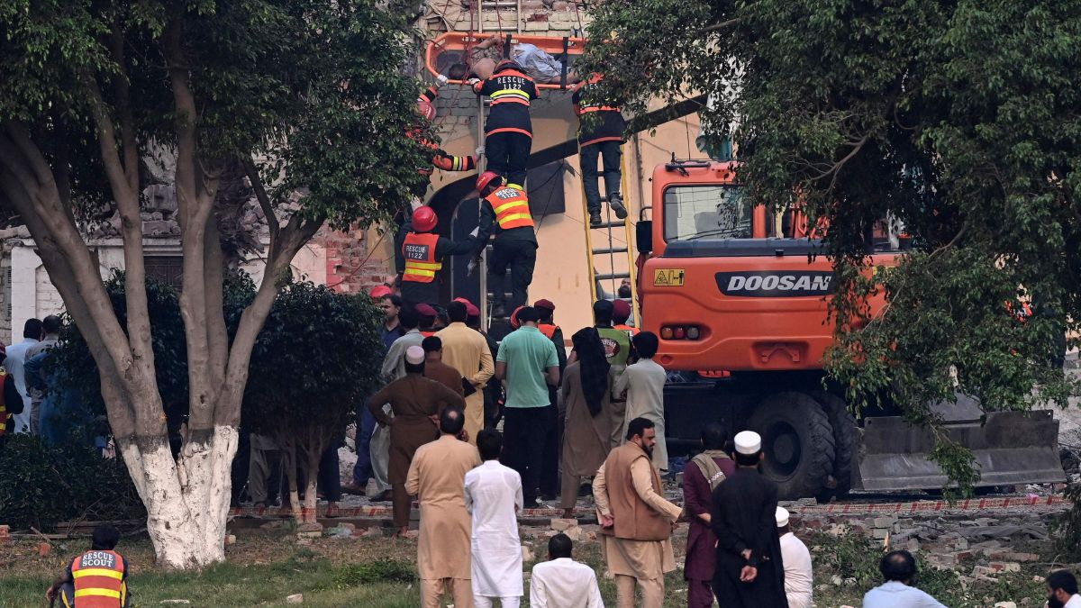 Rescuers move the dead body of a victim amid the debris of a damaged building of the Government Health and Educational complex after Indian strikes in Muridke | AFP 