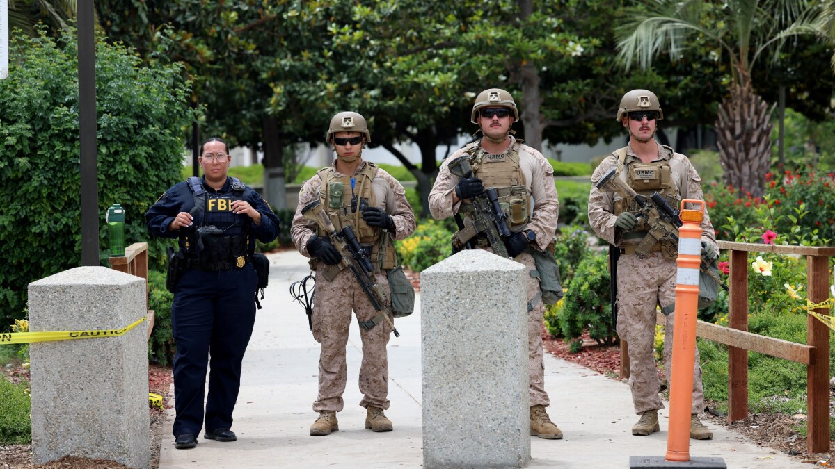 An FBI agent and U.S. Marines stand guard in front of the Wilshire Federal Building | Reuters