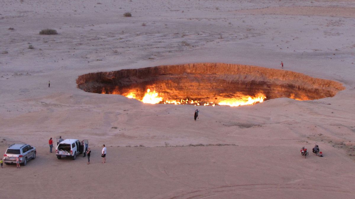 A picture taken on May 3, 2014, shows people visiting "The Gateway to Hell," a huge burning gas crater in the heart of Turkmenistan's Karakum desert | AFP