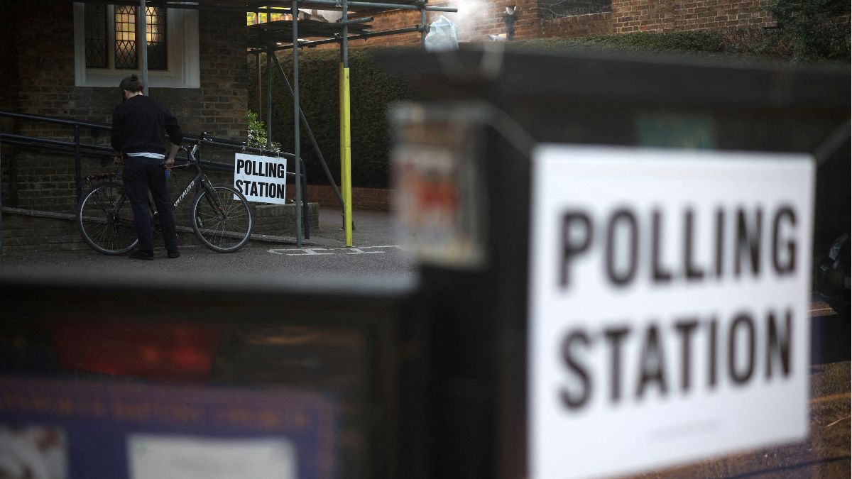 A man unlocks his bicycle after voting at a polling station in Rickmansworth, Britain on May 1, 2025 | Reuters